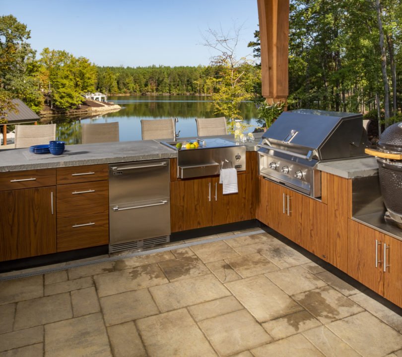 outdoor kitchen with lake view and wood cabinets