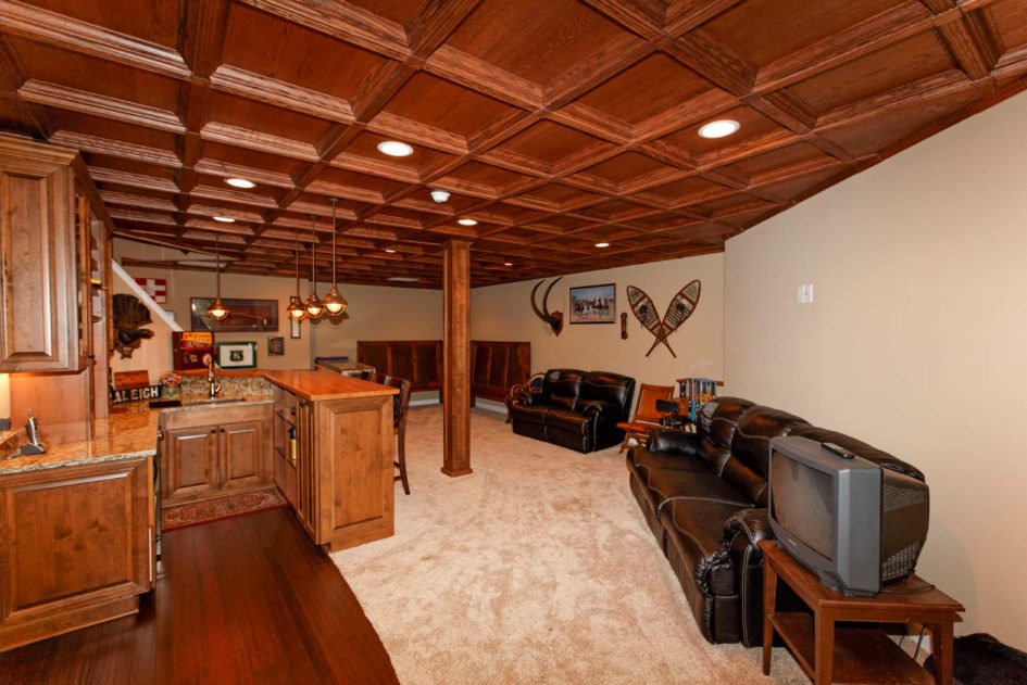 basement with wood panel cieling and bar area